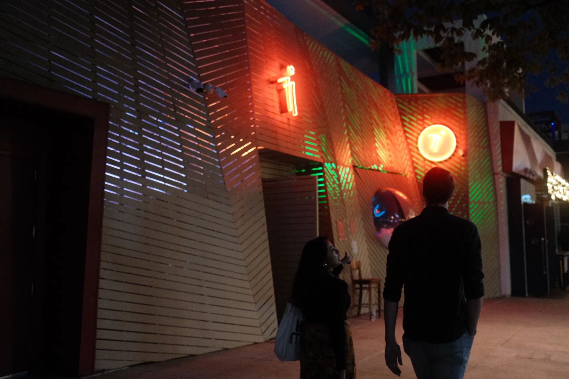 A couple walking by a club in the Domain