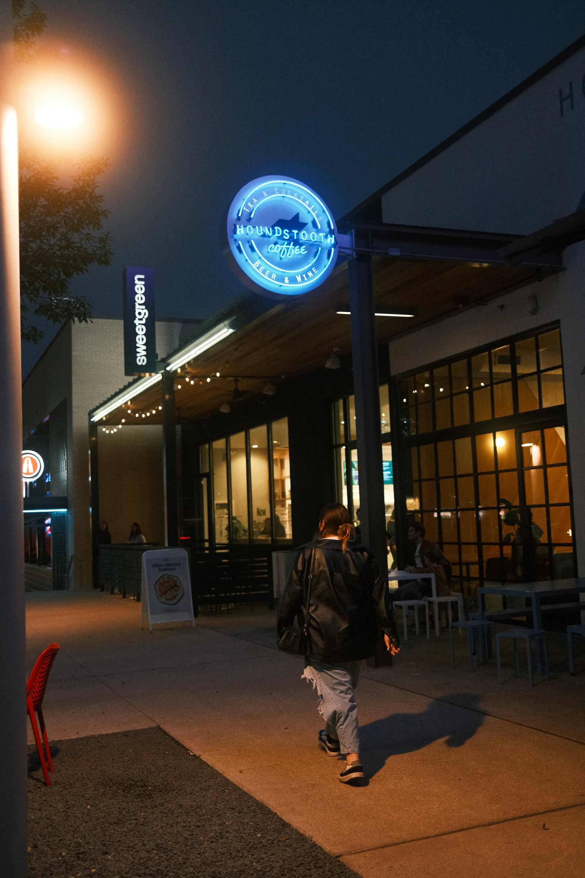 A woman walks by Houndstooth Coffee