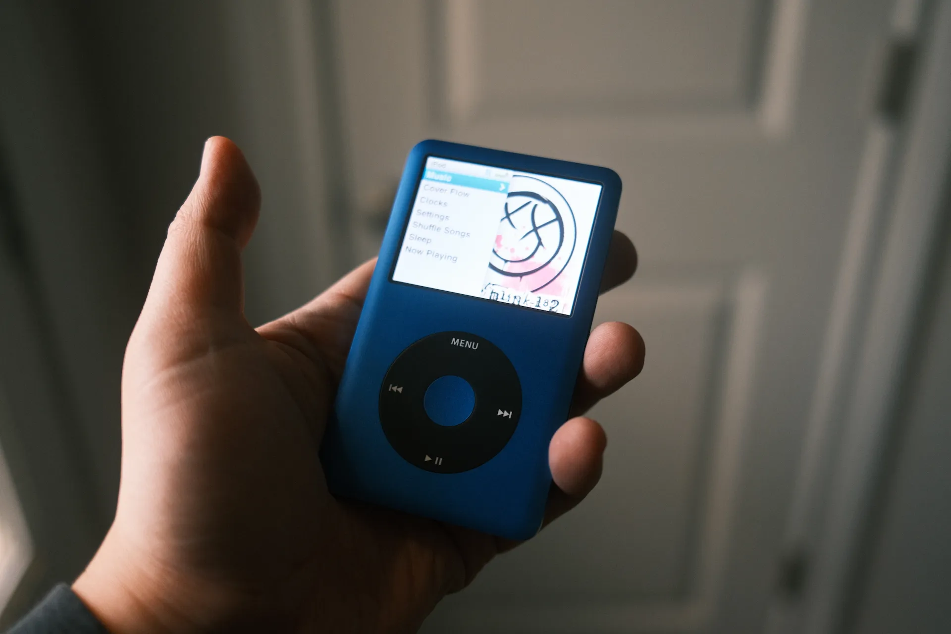 holding a custom iPod Classic with black clickwheel and blue aluminum shell