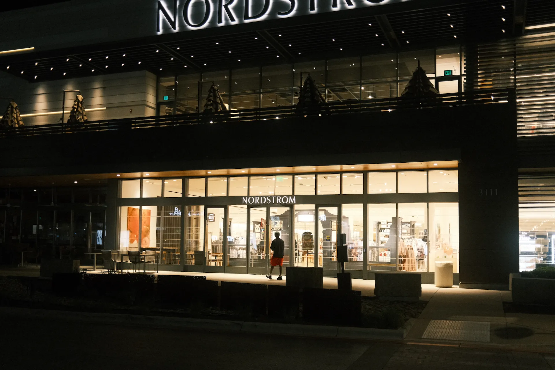 A guy in red shorts walks by Nordstrom